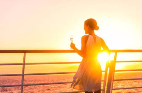 A woman admiring the sunset on a cruise ship