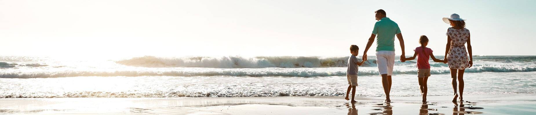 Panoramic image of a family at the beach on their summer holiday