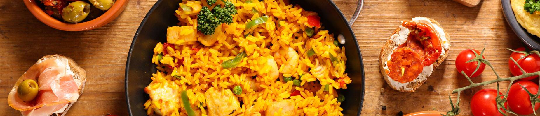 Panoramic image of paella and other popular Spanish cuisine