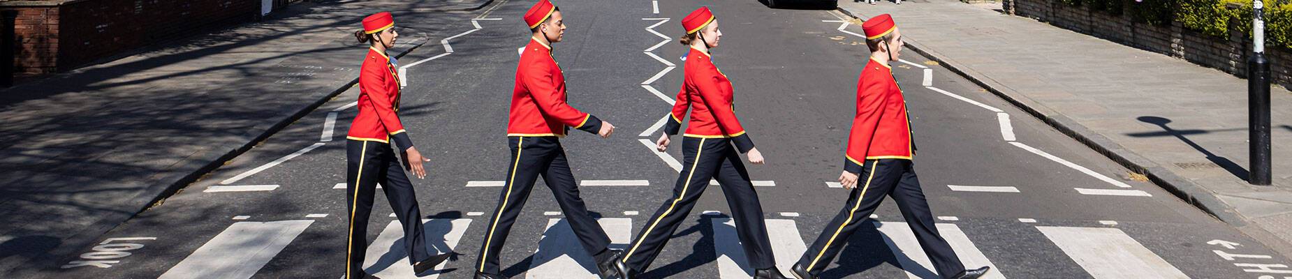 Four Cunard bellhops crossing Abbey Road