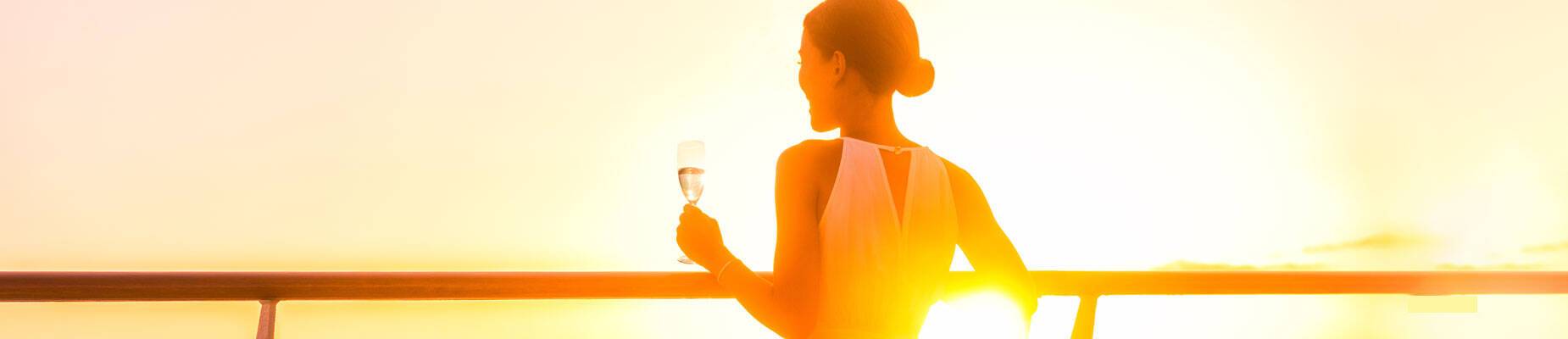A woman looking out to sea at sunset